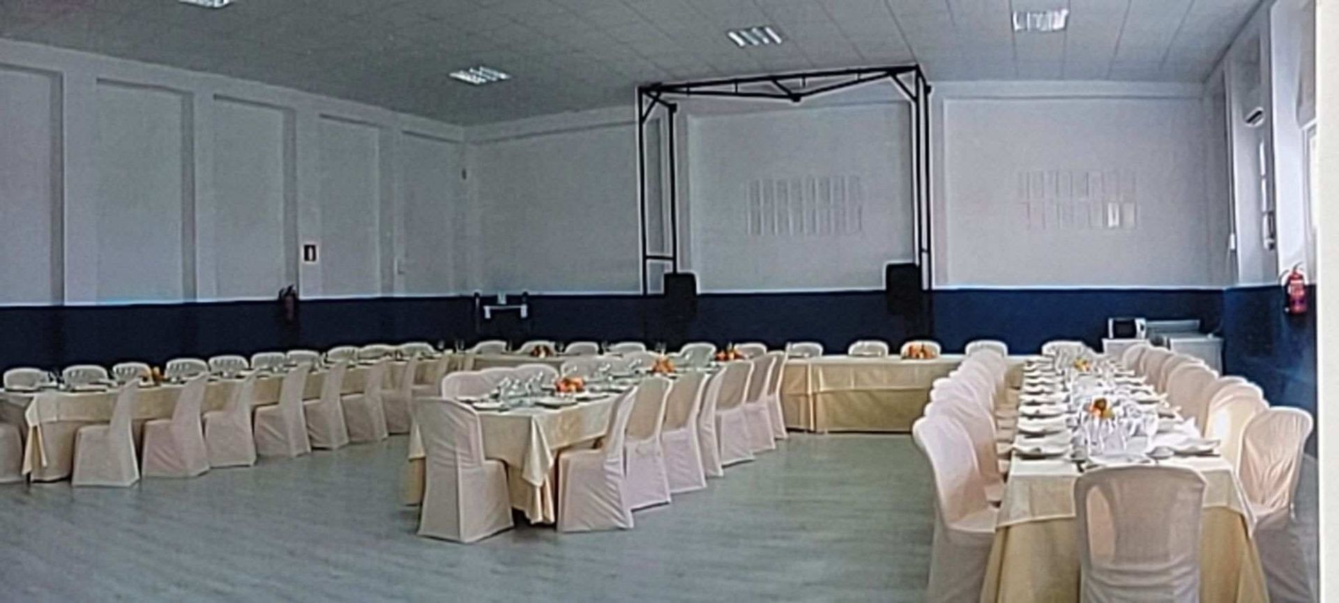 Una gran sala con mesas y sillas preparadas para una fiesta.