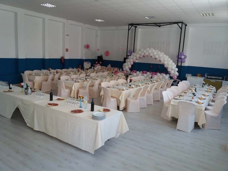 Una gran sala con mesas y sillas preparadas para una fiesta.