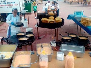 Una mujer está cocinando comida en una parrilla en un restaurante.