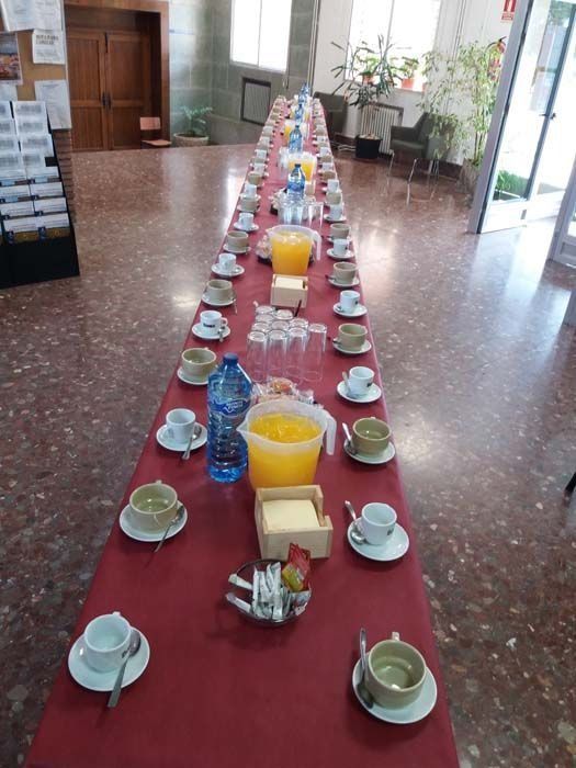 Una mesa larga con platos y tazas encima.