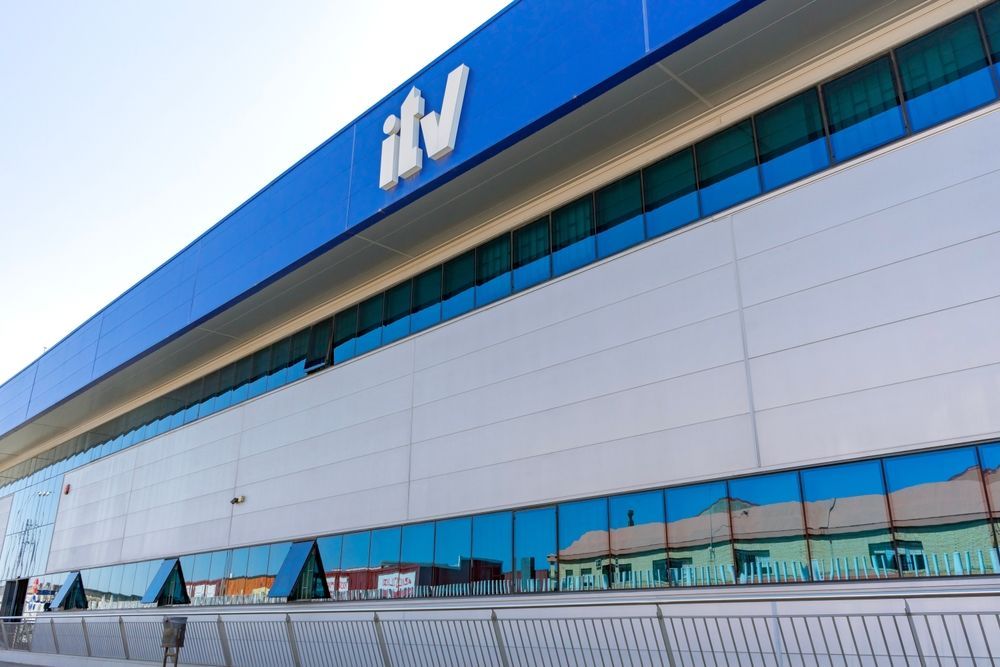 Un edificio moderno con una gran fachada azul que luce el logotipo blanco de 