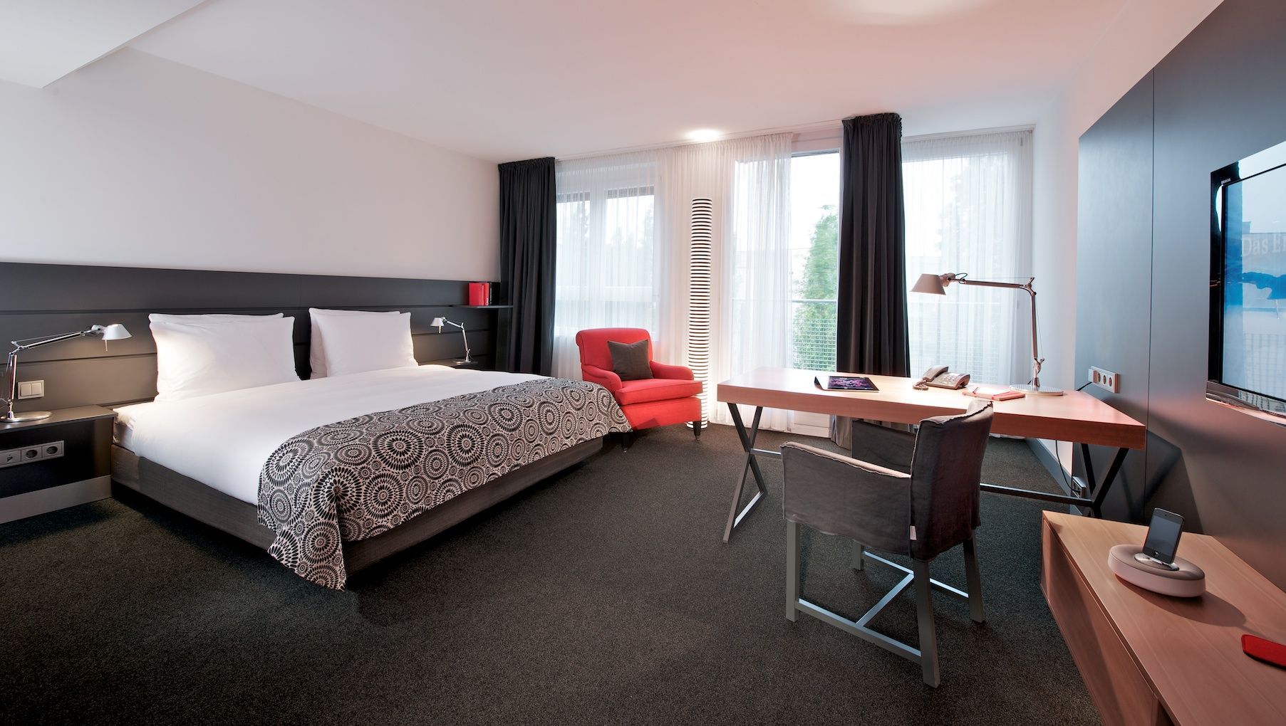 Ein Hotelzimmer mit Kingsize-Bett und Schreibtisch