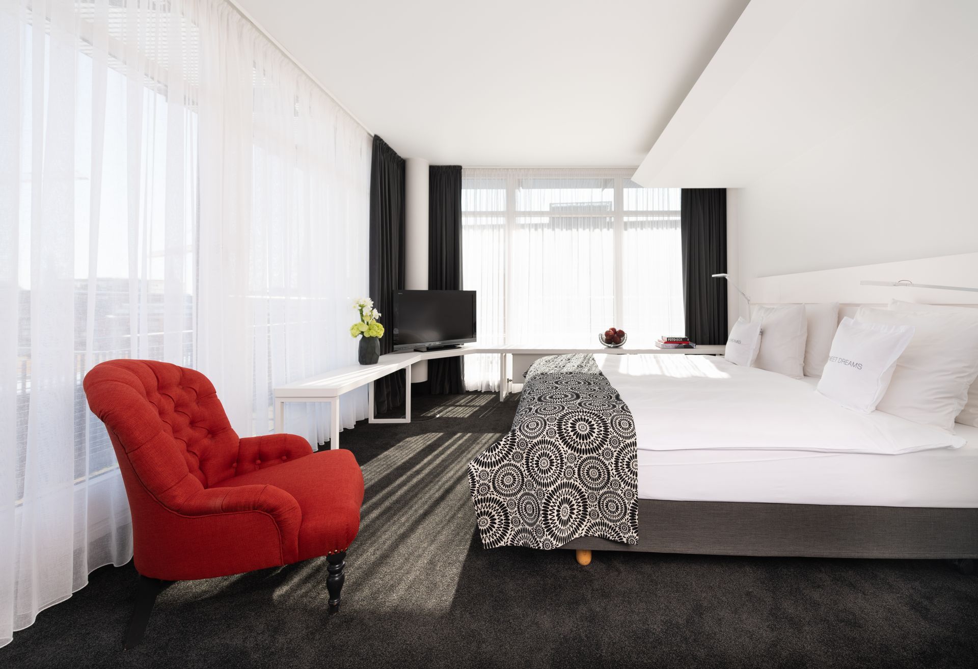 Ein Hotelzimmer mit einem großen Bett und einem roten Stuhl