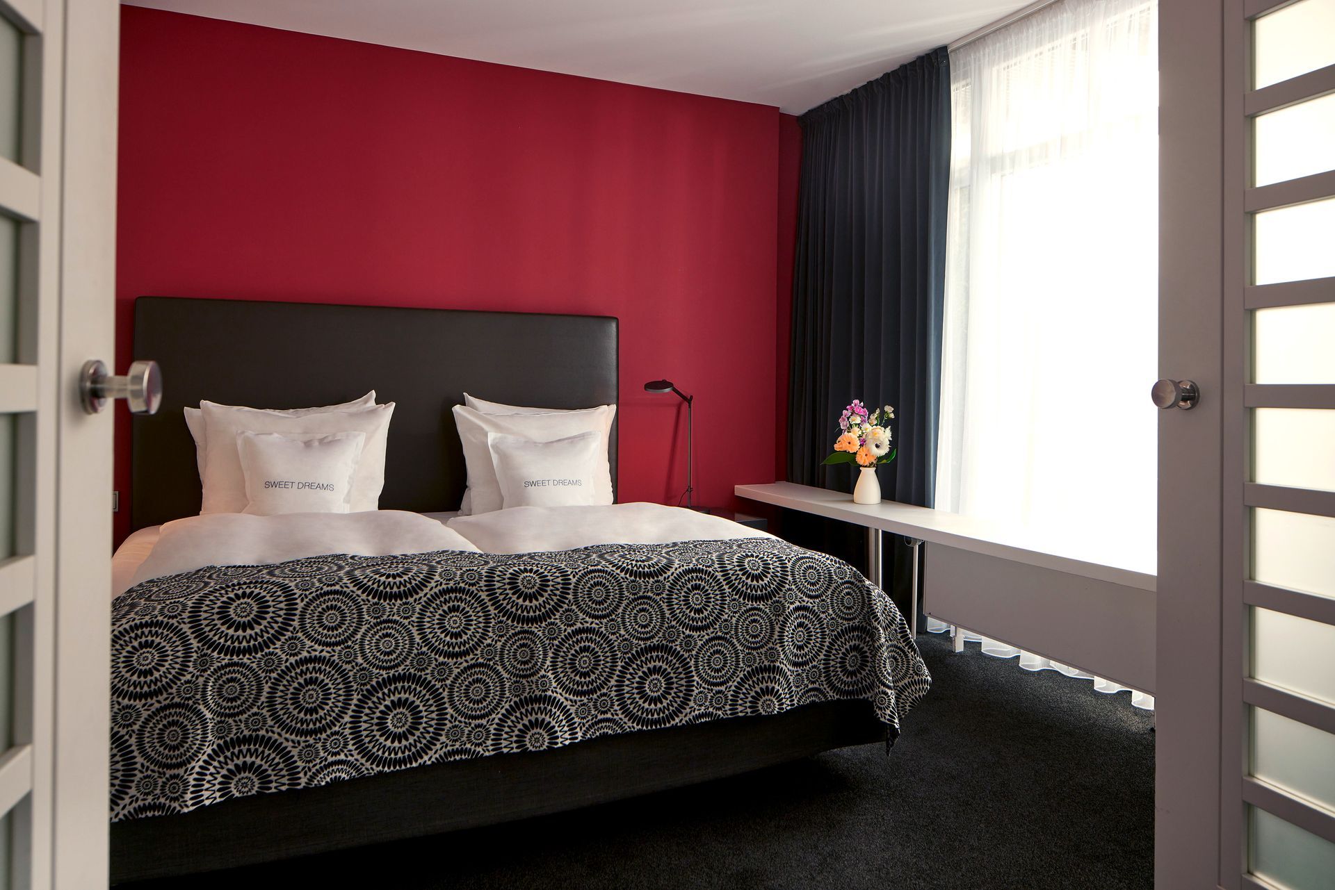 Ein Hotelzimmer mit einem Bett und einer roten Wand