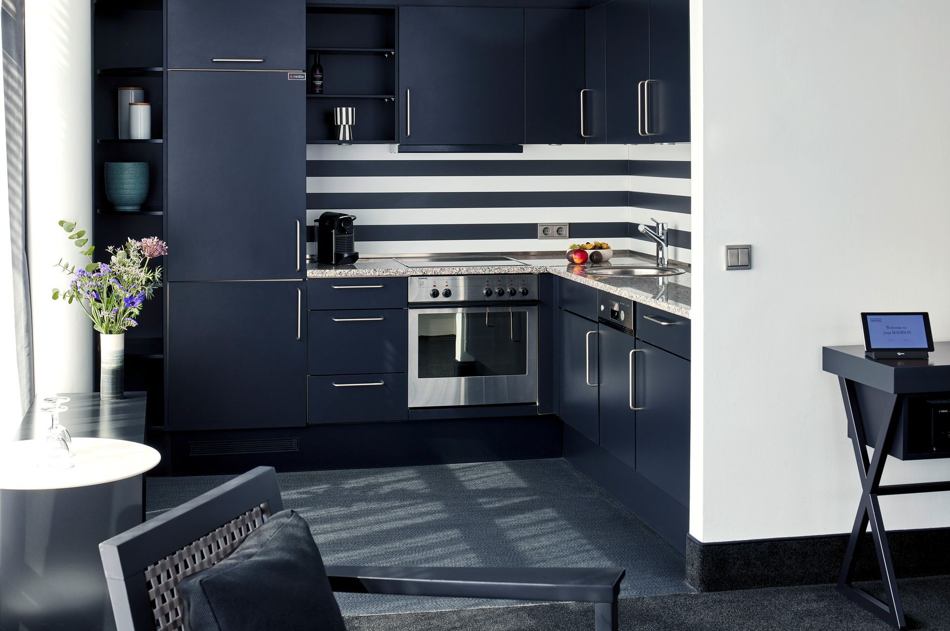 Eine Küche mit blauen Schränken und weißen Streifen an der Wand