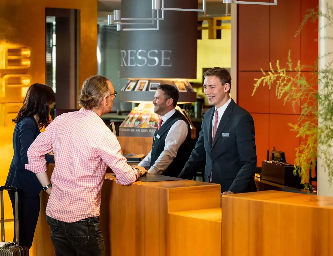 A man in a suit and tie is standing at a counter in a restaurant.