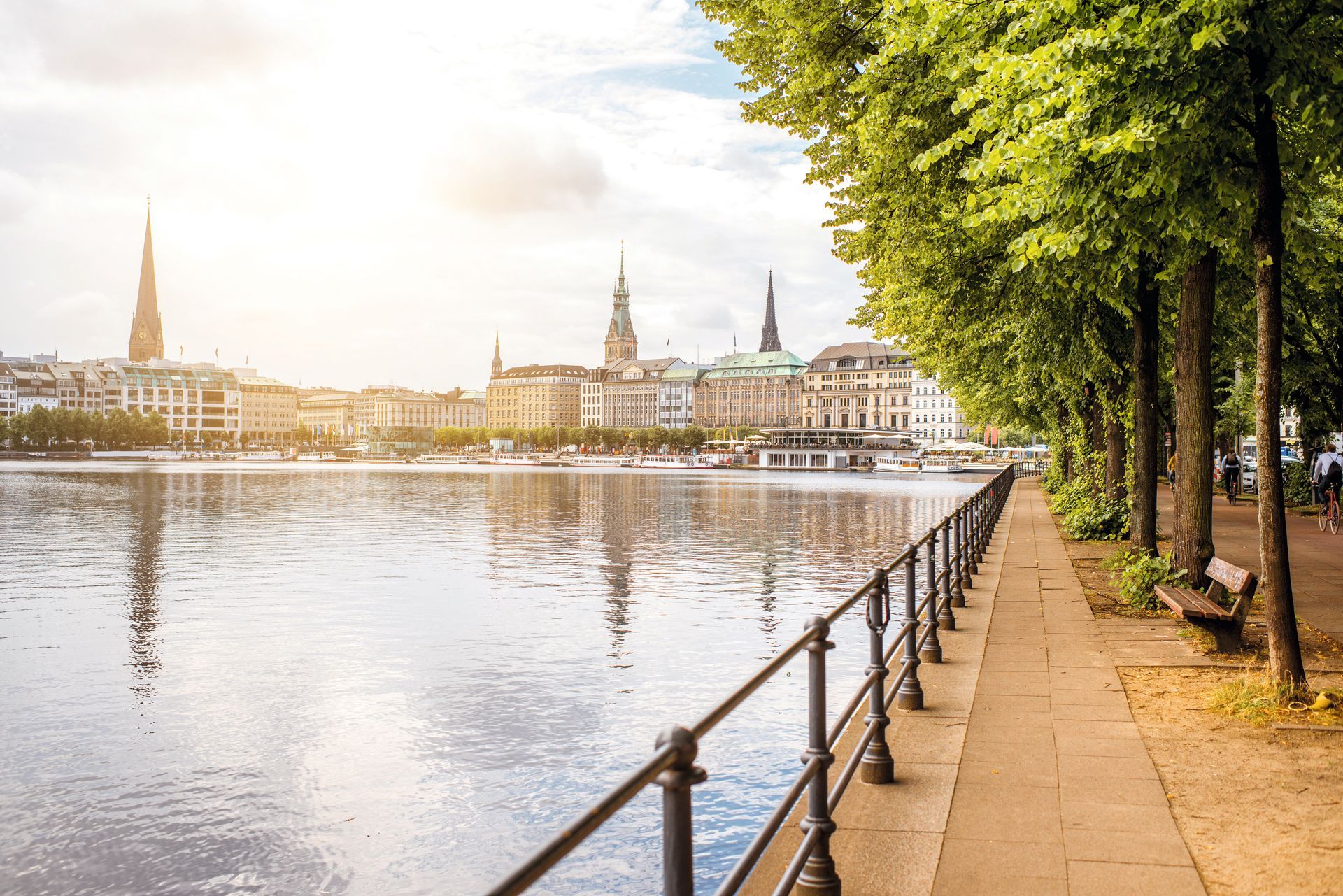 Ein Fluss mit einer Stadt im Hintergrund und einem Zaun am Ufer.