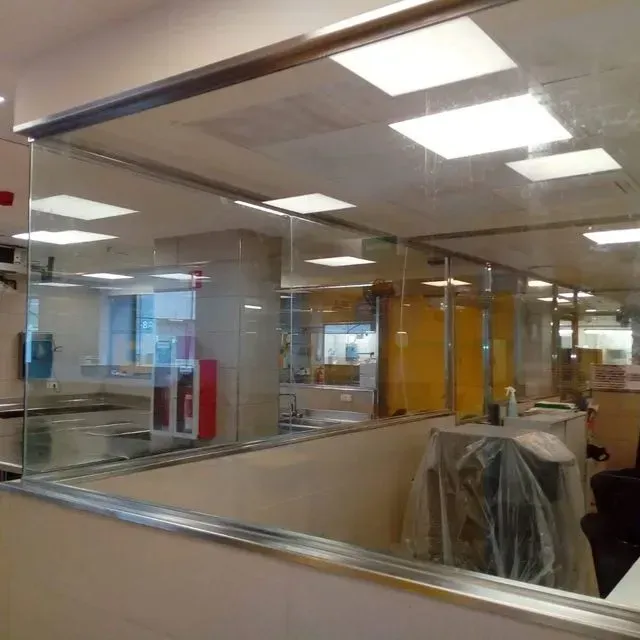 Un cubículo en una oficina con una pared de vidrio