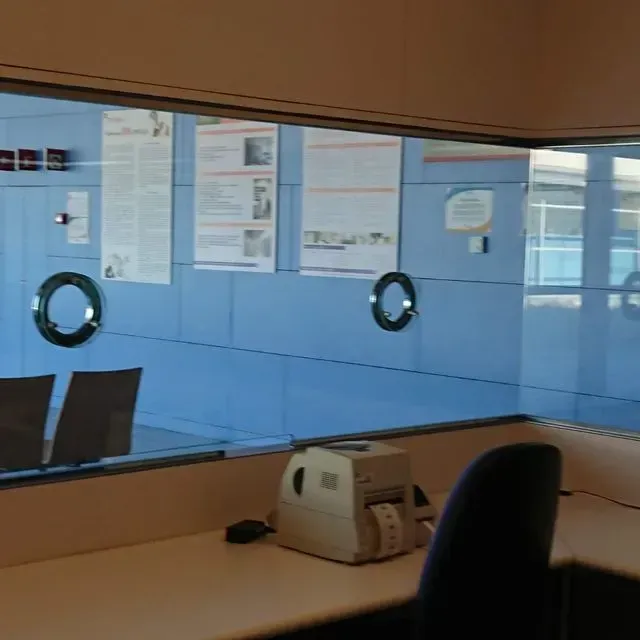 Una impresora blanca se encuentra en un escritorio frente a una ventana.