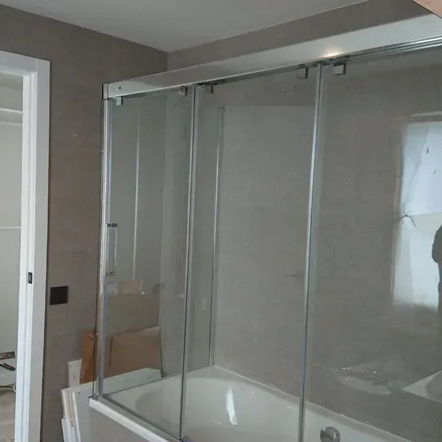 Un baño con bañera y ducha con puerta corrediza de cristal.