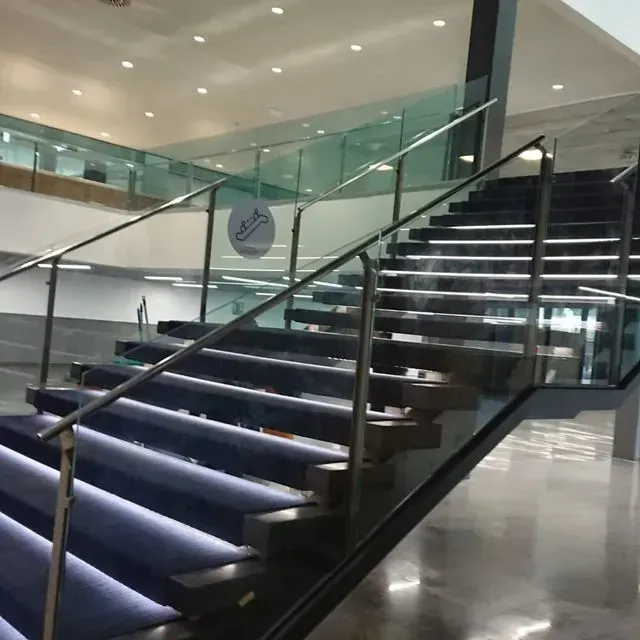 Una escalera con barandilla de cristal y un cartel que dice 'allianz'.