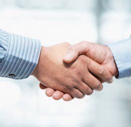 Dos personas se dan la mano, simbolizando un acuerdo o un trato.