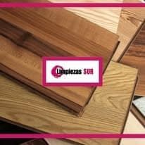 Varias muestras de pisos de madera de color marrón claro y medio están apiladas, con el logotipo