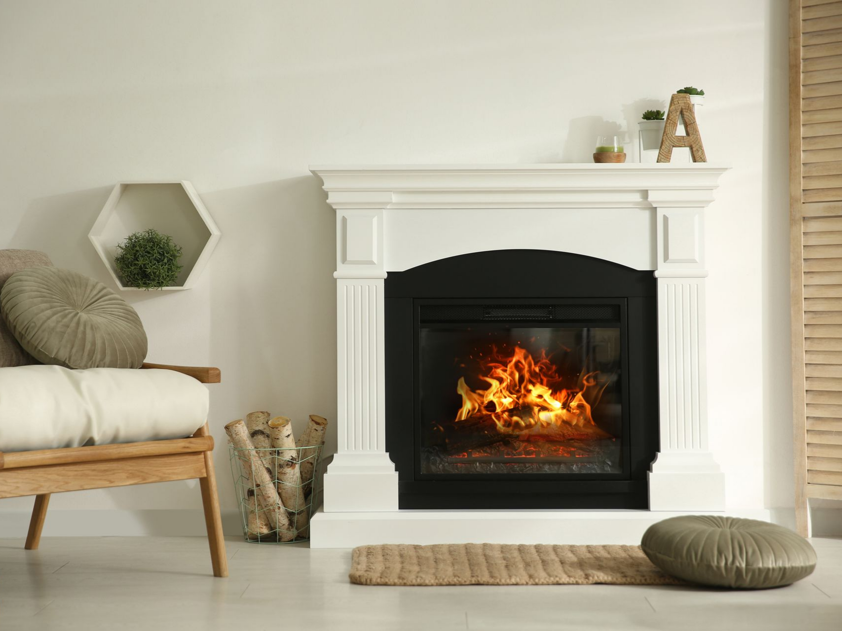 Vers la page Installation de cheminée. Salon avec cheminée, bûches, fauteuil en bois, étagère décorative.