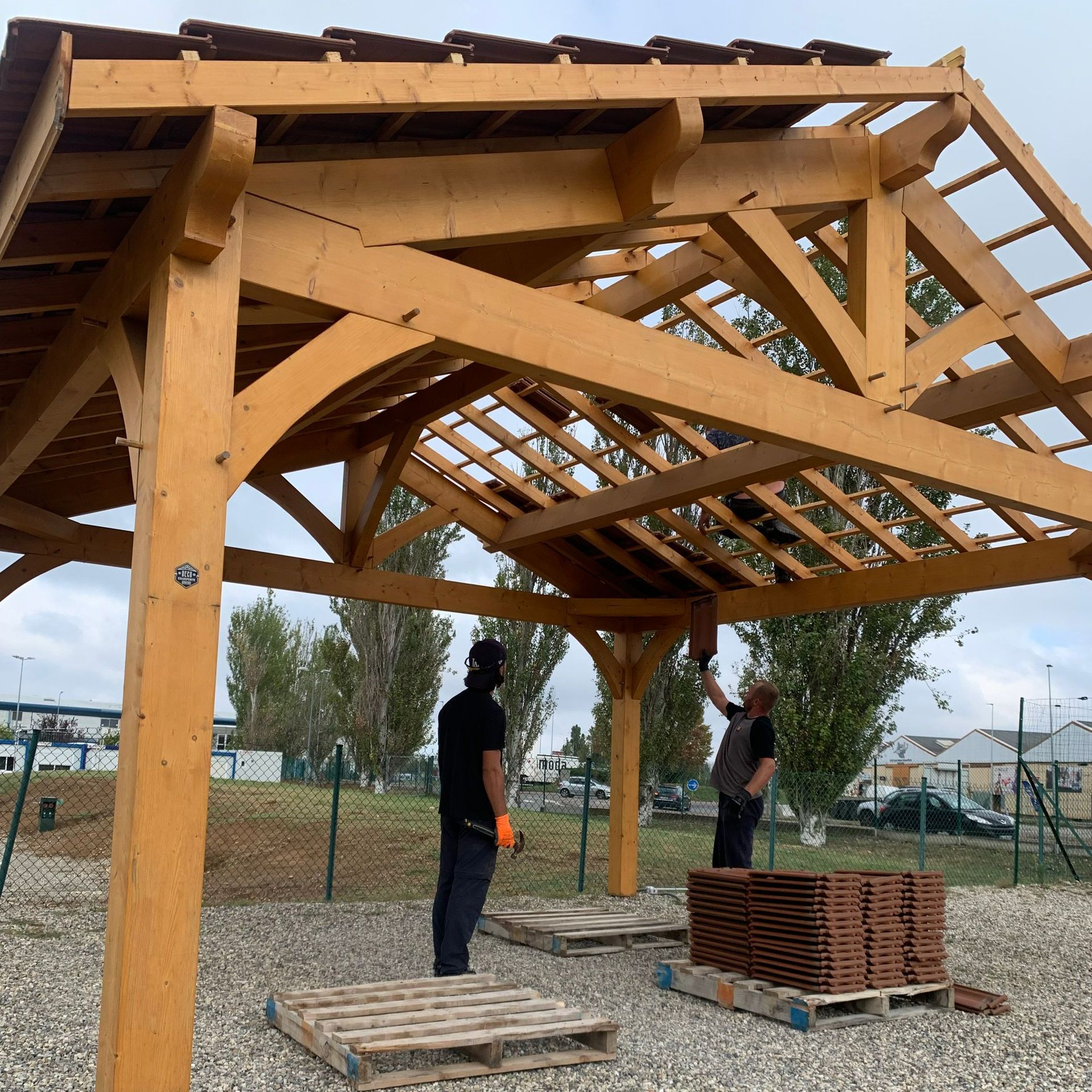 Deux artisans sous une charpente en bois