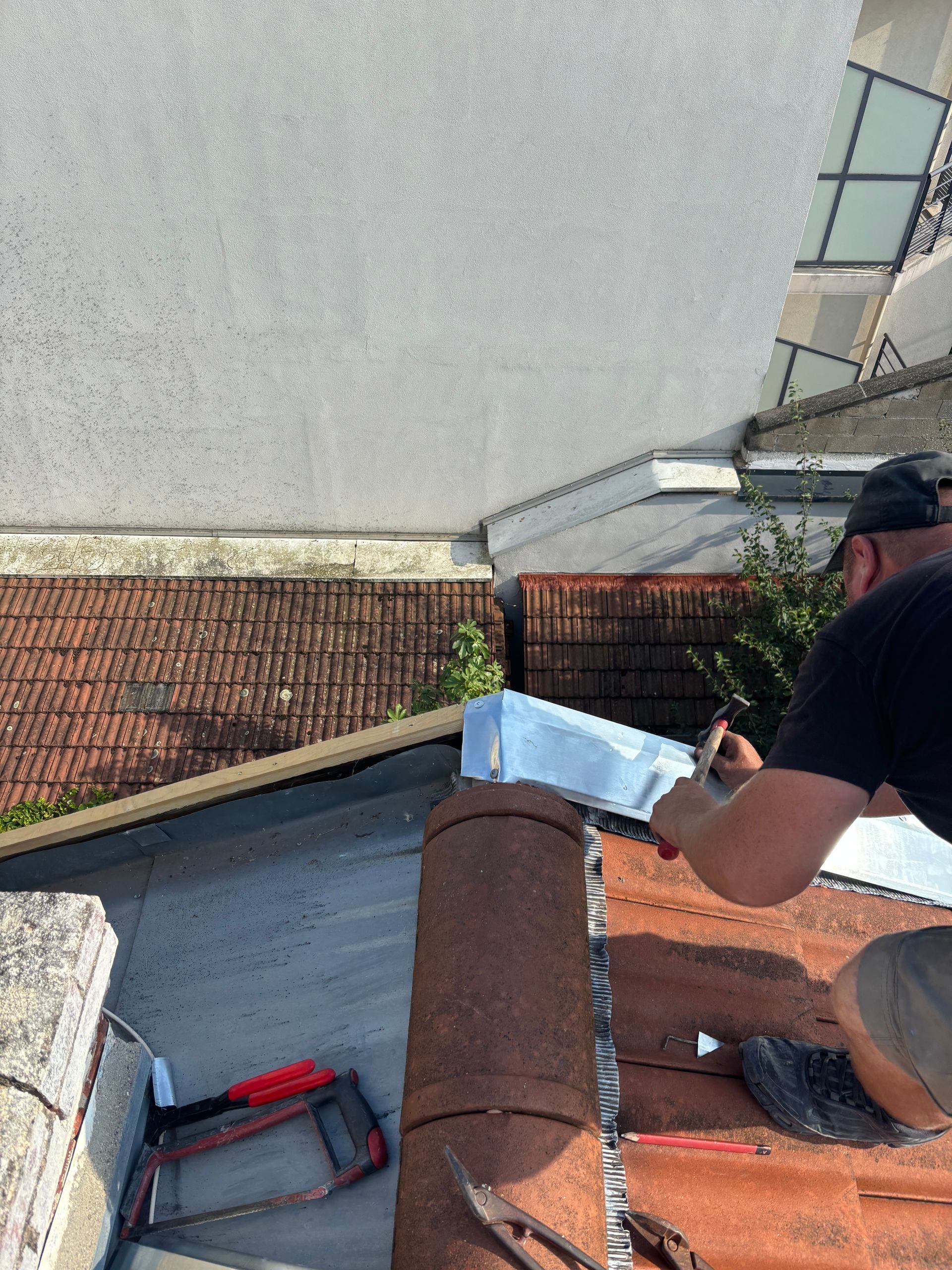 Artisan qui pose éléments en zinc sur une toiture