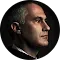 Retrato de perfil de una persona con cabello corto, iluminado sobre un fondo oscuro.