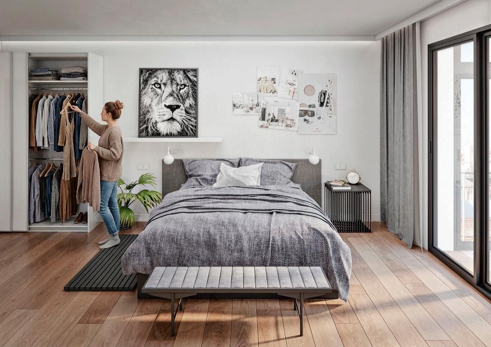 Una persona selecciona ropa de un armario abierto en un dormitorio moderno con una cama central