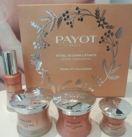 Coffret de soins Payot avec une boîte rose et trois pots posés sur une surface claire