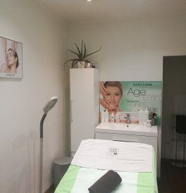 Petite cabine de soins esthétiques avec une table de massage,