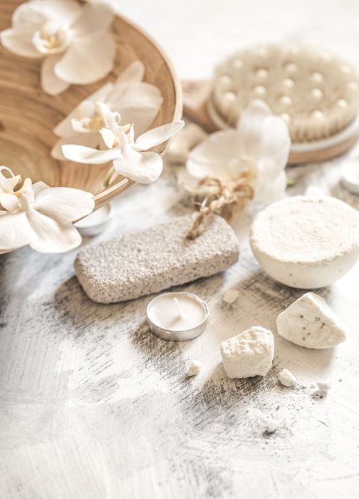 Nature morte de spa avec des fleurs blanches, des pierres, des galets et des pinceaux sur un fond beige doux