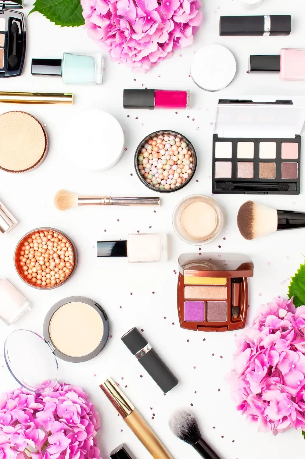 Hay muchos tipos diferentes de cosméticos y pinceles sobre la mesa.