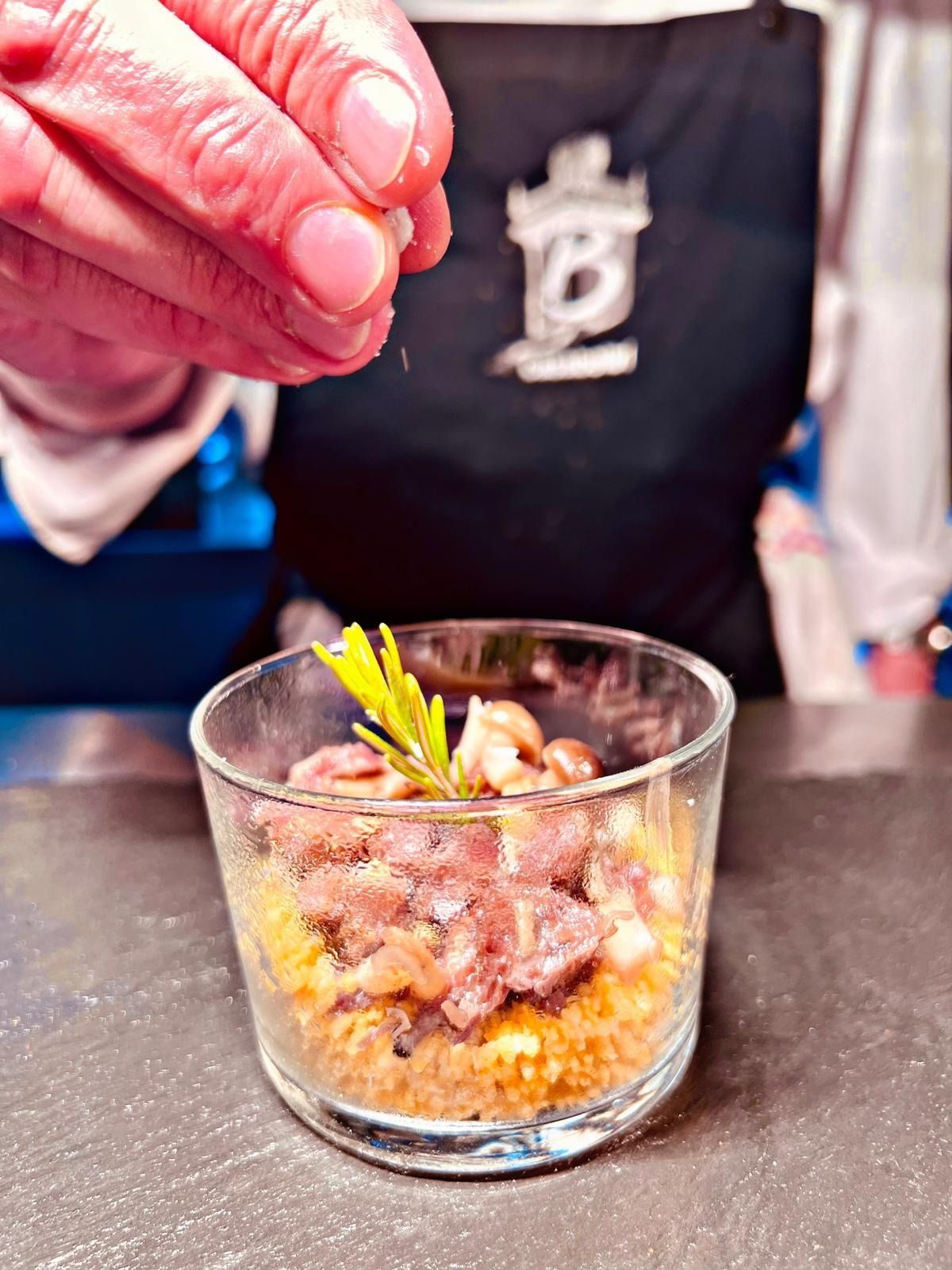Una persona está rociando sal sobre un recipiente con comida.