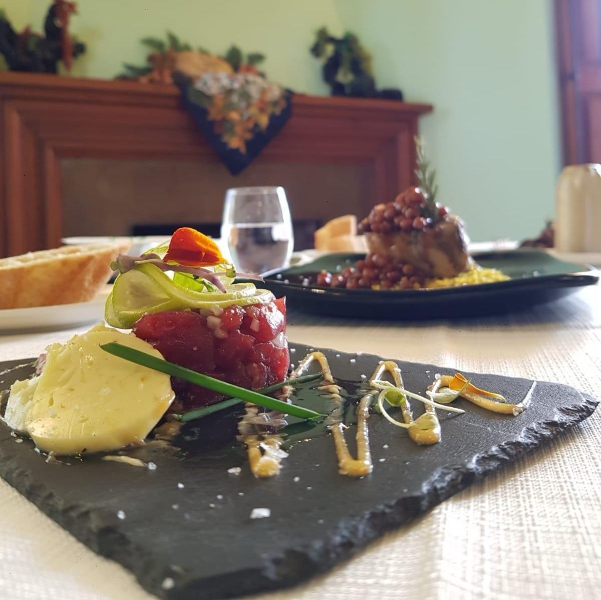 Un plato de comida en una mesa con una chimenea al fondo.