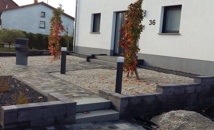 Frau pflanzt Blumen im Garten
