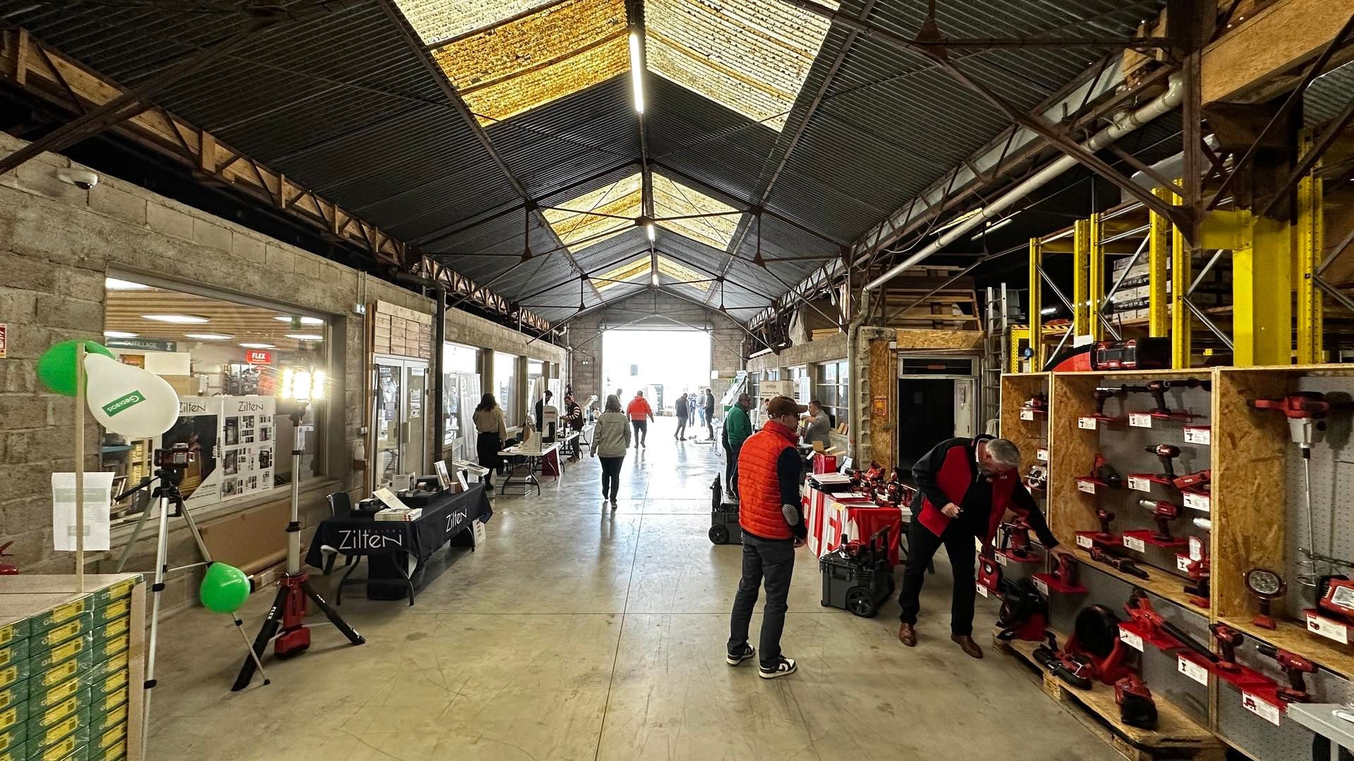 Des clients examinent les marchandises dans un grand entrepôt.