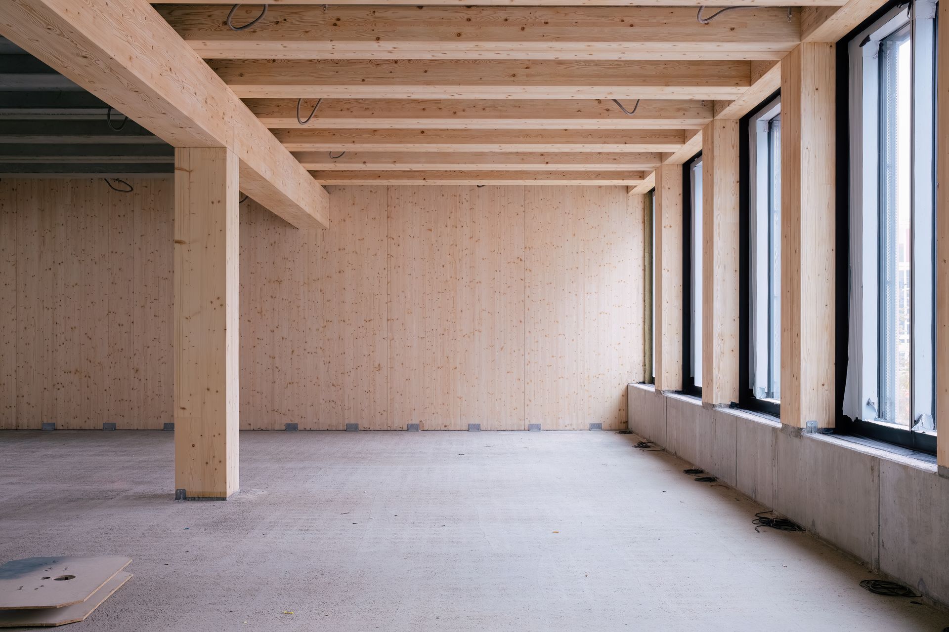 Rénovation de la cuisine en cours : armoires blanches, structure de l’îlot en bois, fenêtres et ustensiles sur les comptoirs.