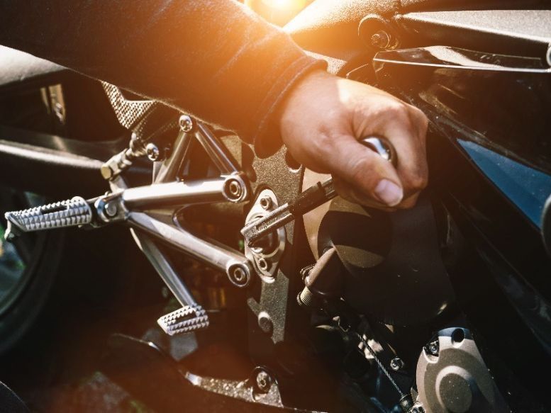 Un primer plano de la mano de una persona en una motocicleta.