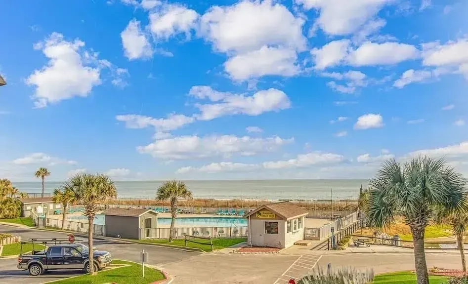 A view of the ocean from a balcony of a house.