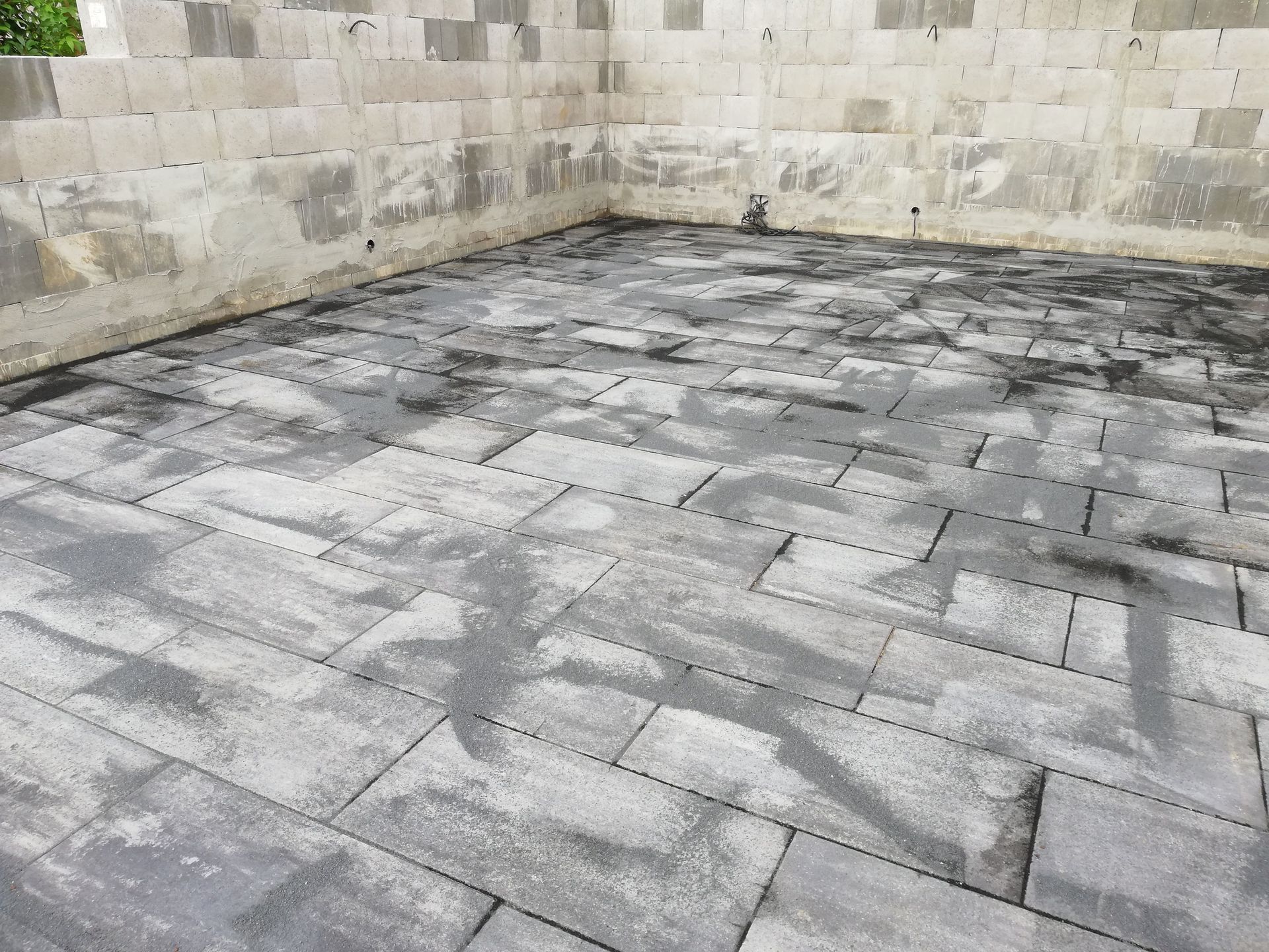 Graue Ziegelterrasse mit Betonblockwänden im Bau.