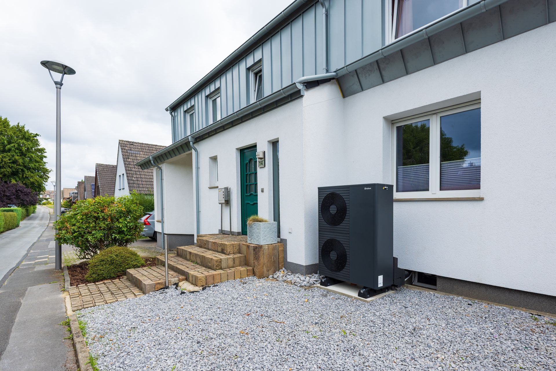 Une buanderie avec pompe à chaleur blanche, chauffe-eau et tuyauterie de raccordement.