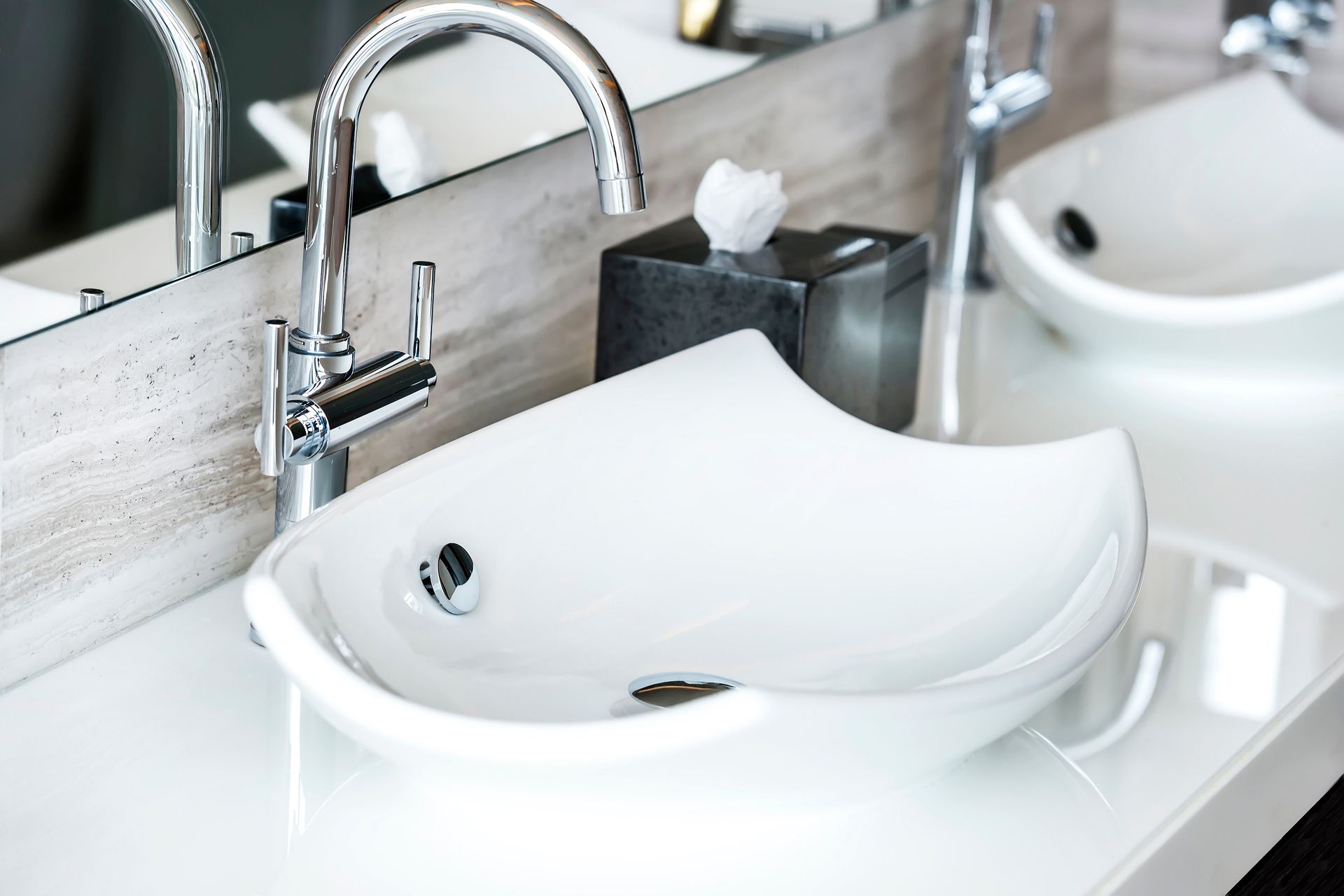 Salle de bains moderne avec baignoire îlot, douche en verre et poutres apparentes au plafond.