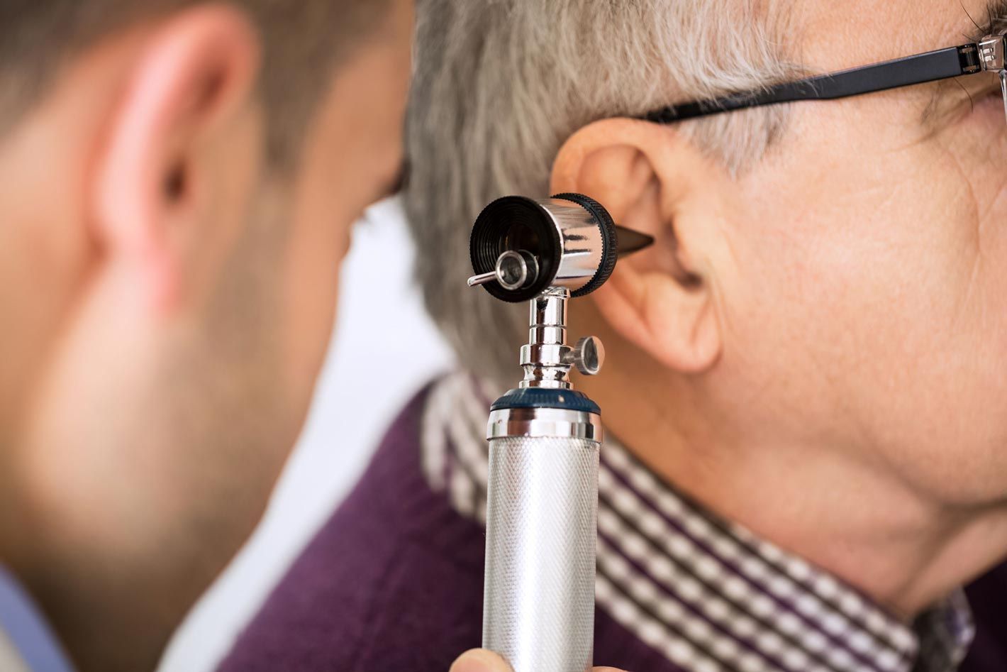Un hombre se hace examinar el oído por un otorrinolaringólogo.