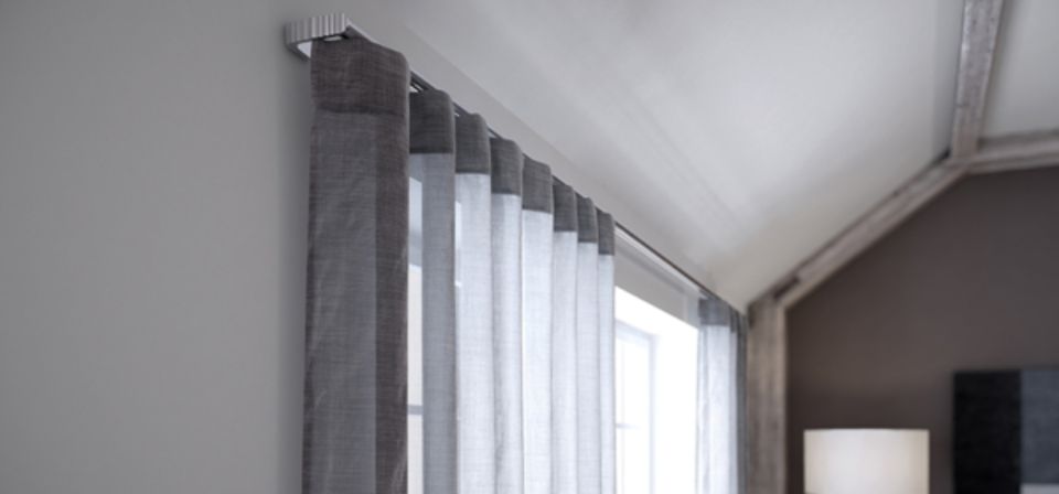 Eine Nahaufnahme eines Fensters mit Vorhängen in einem Zimmer