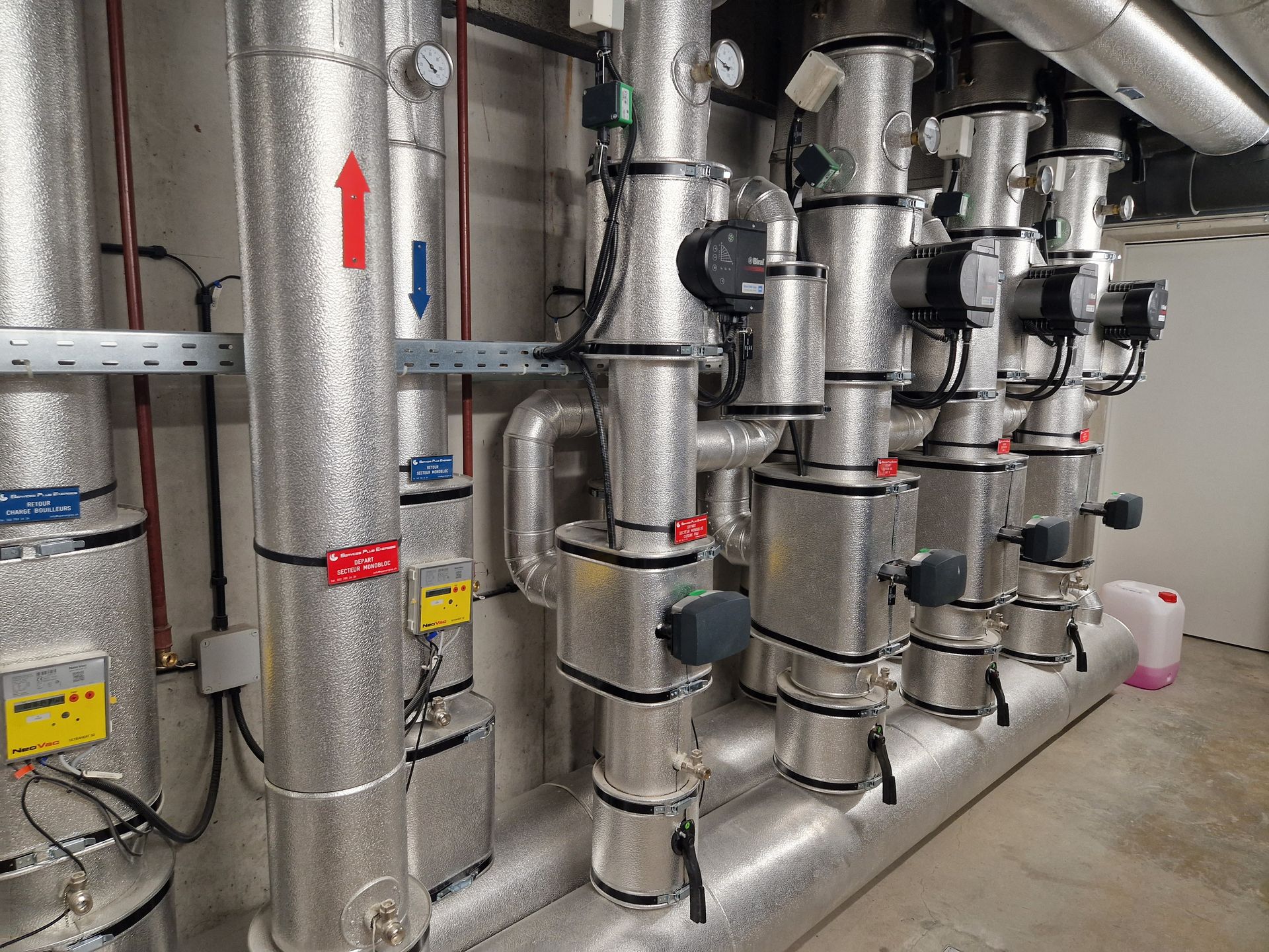 Une maison modèle, une calculatrice, une ampoule et un stylo sont sur une table.