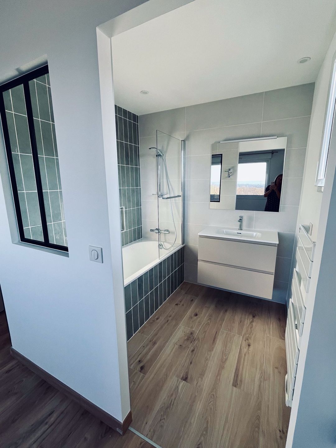 Salle de bains moderne avec carrelage différent pour séparer les espaces.
