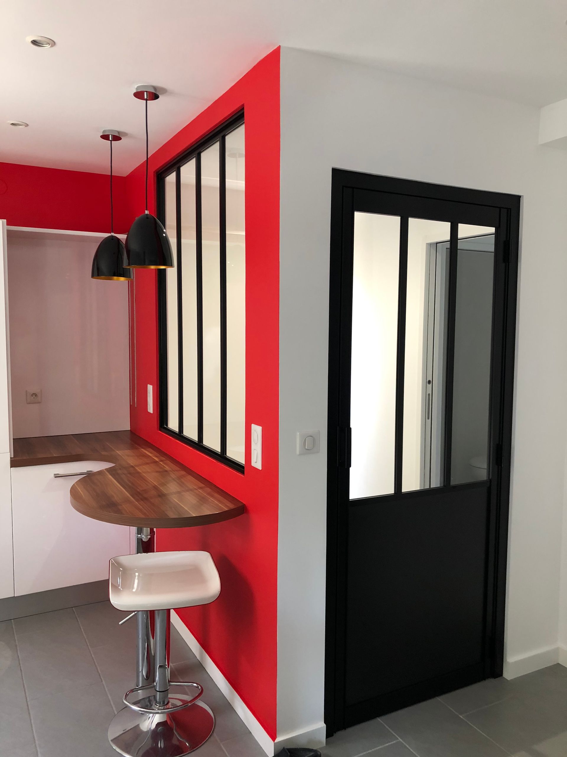 Porte et fenêtre donnant sur une cuisine avec plan de travail en bois.