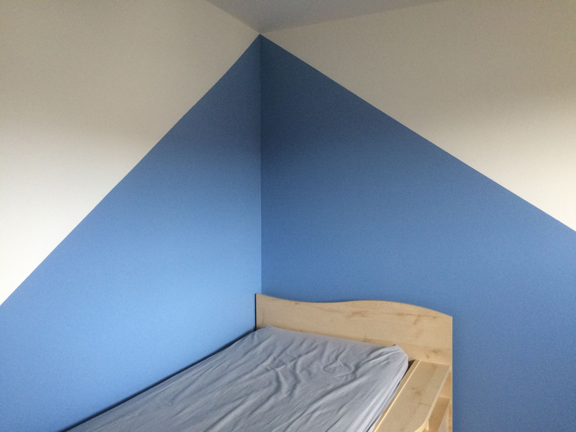 Espace au dessus d'un lit démarqué avec de la peinture bleue.