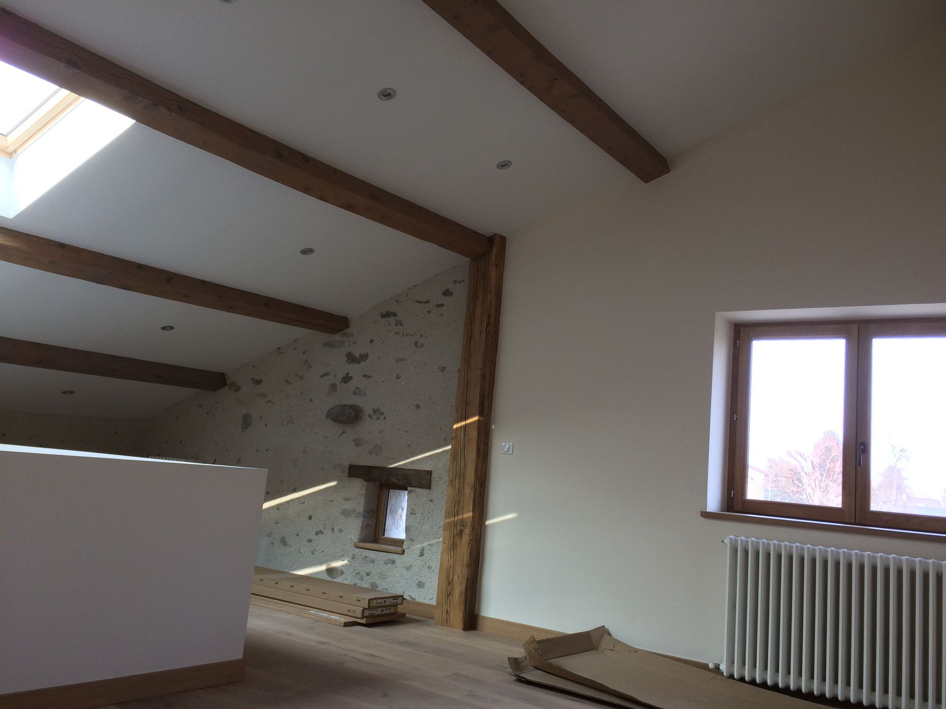 Combles en cours d'aménagement avec plafond peint en blanc.