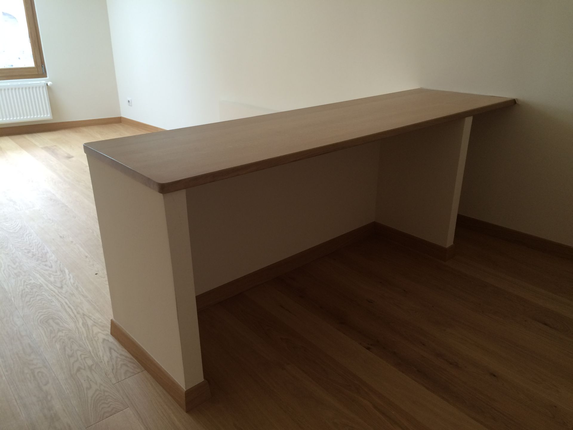 Plan de travail en bois dans une pièce possédant un parquet.