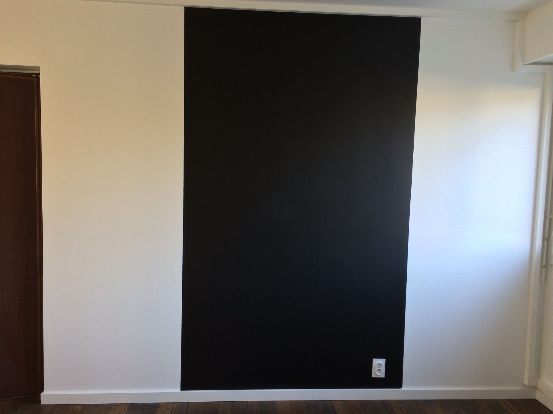 Peinture noire sur une partie d'un mur.