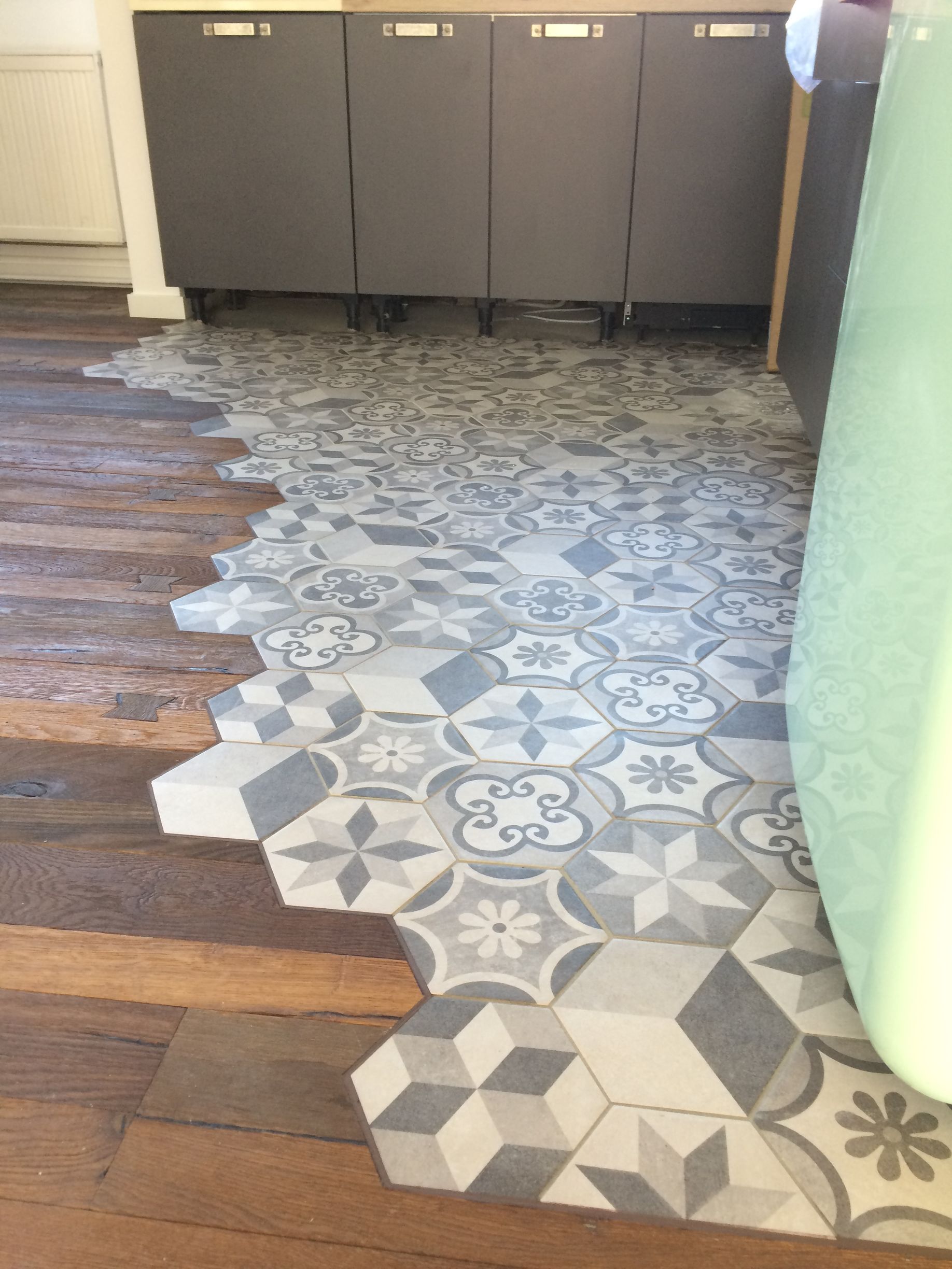 Sol avec séparation atypique entre un sol de cuisine et un parquet.