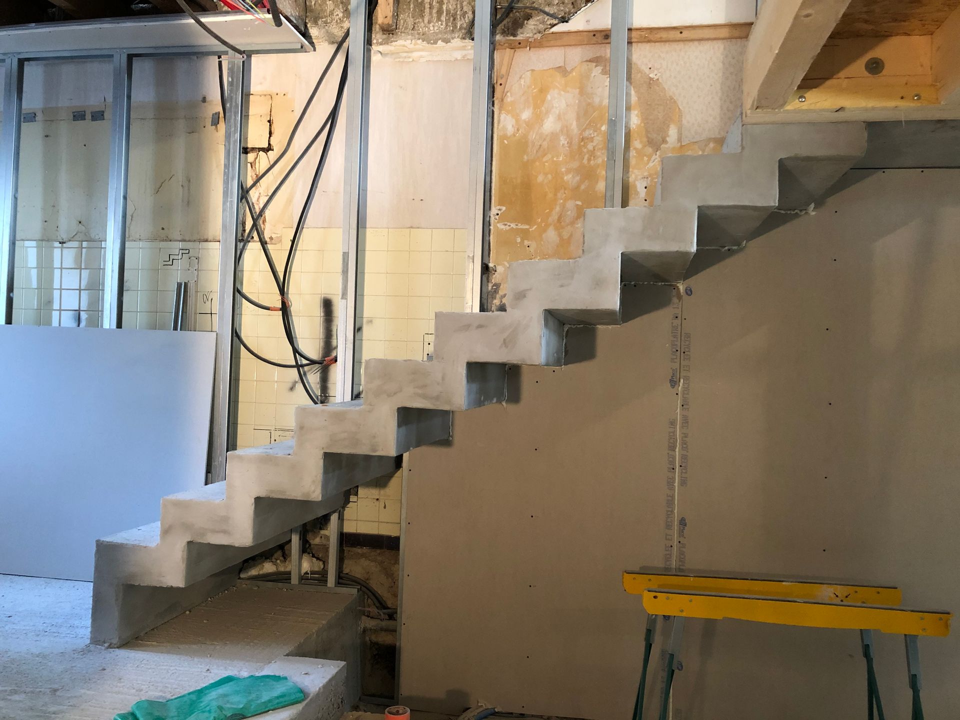 Escalier en béton devant une cloison de séparation de pièce.