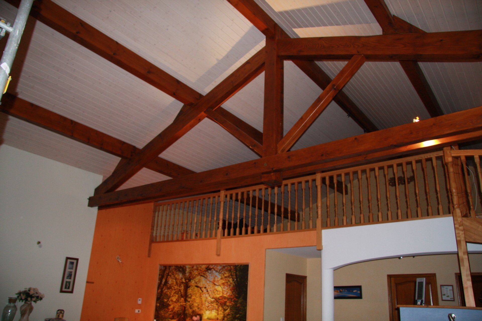 Mezzanine sous combles avec toit peint en blanc.