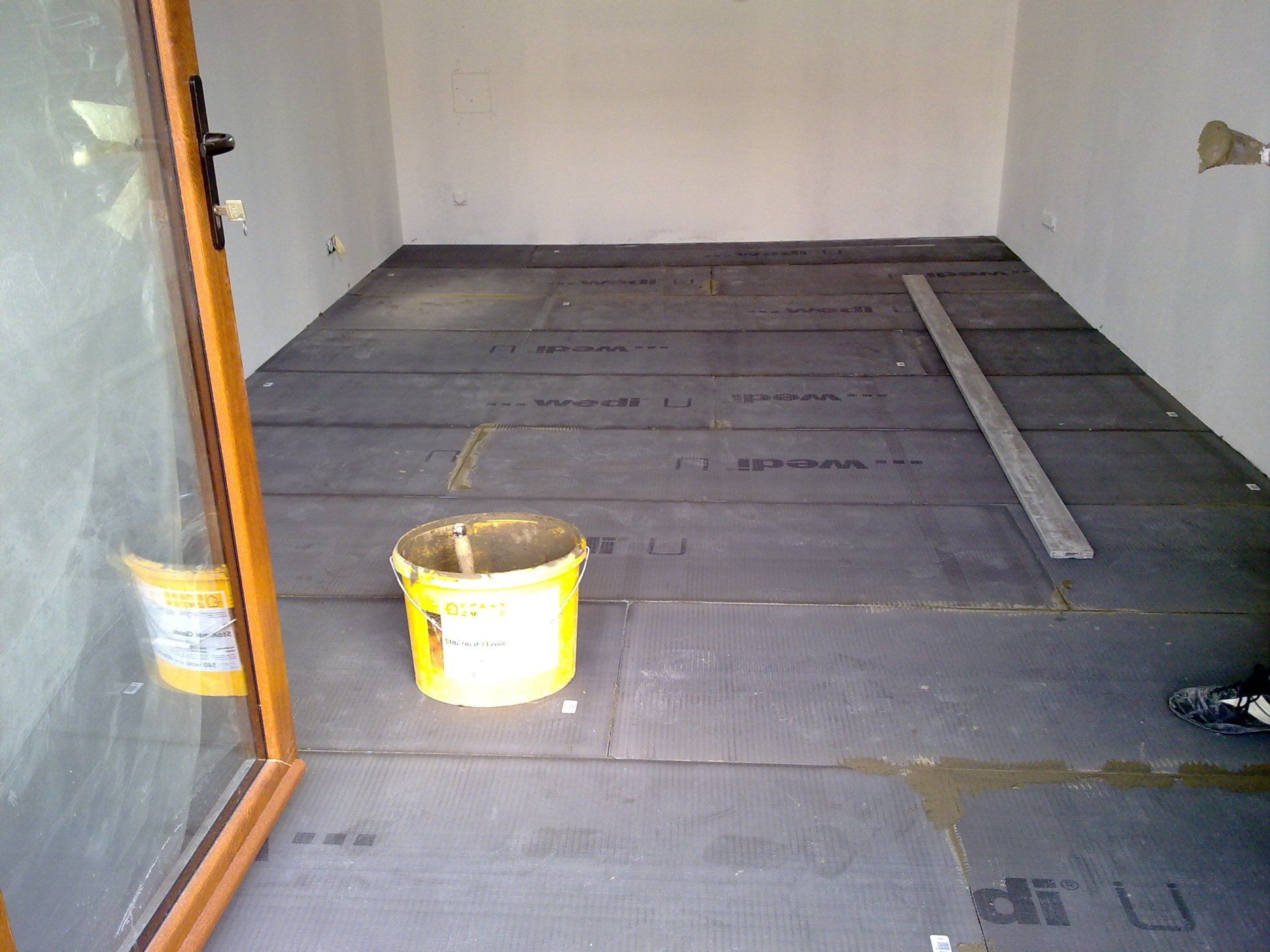 Pièce avec seau jaune durant des travaux.