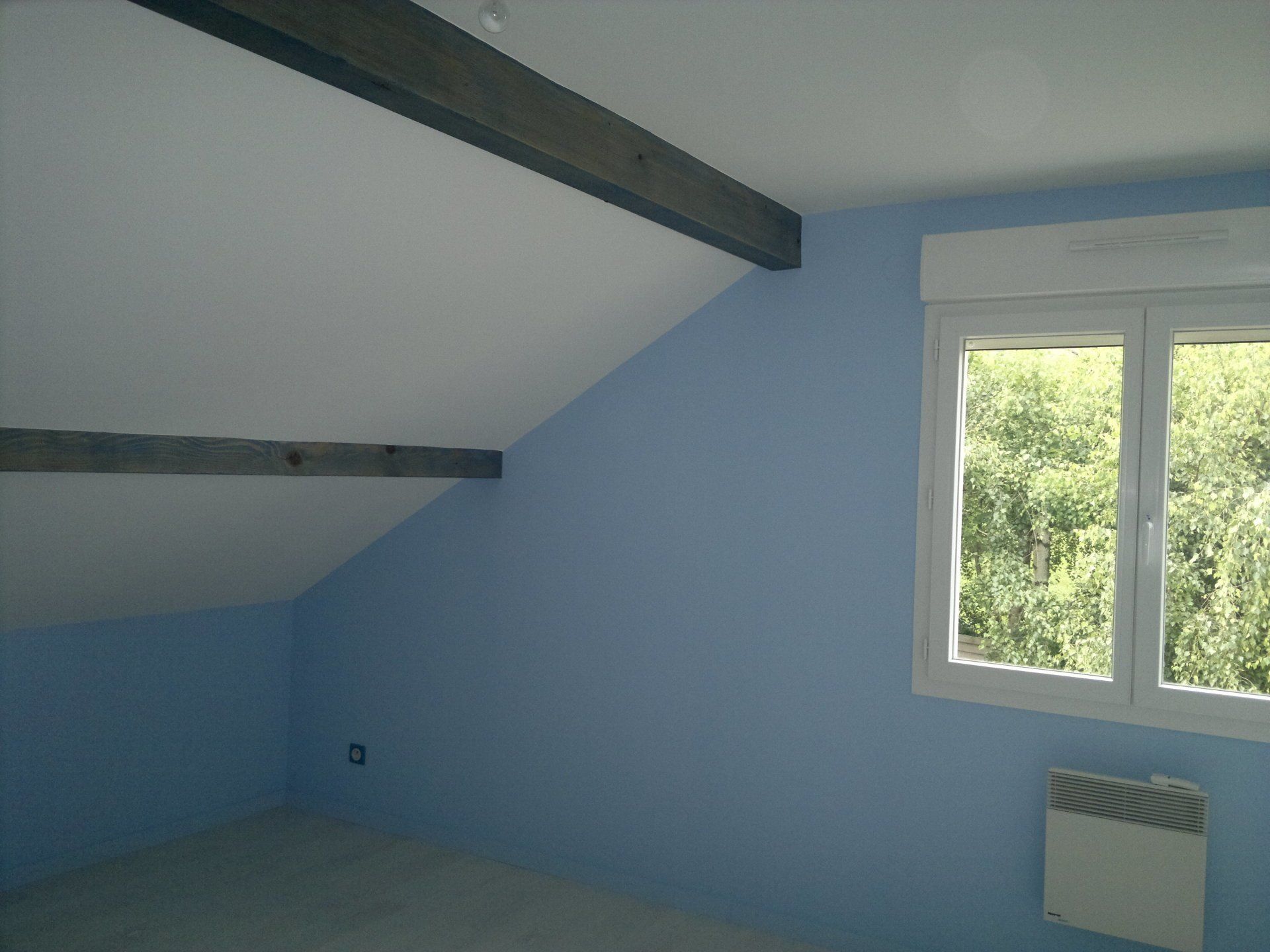 Pièce sous des combles avec mur bleu clair.
